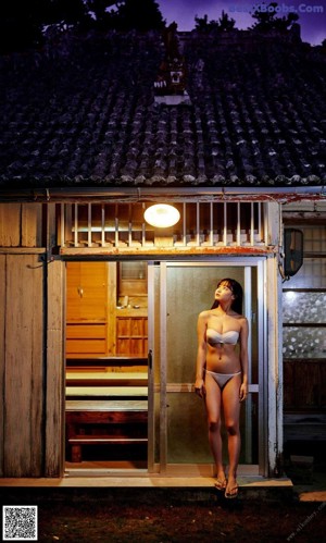 A woman in a white bra laying on a bamboo mat.