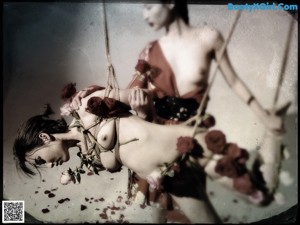 A woman tied up with roses on her back.
