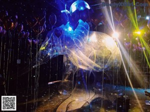 A group of naked people standing in a room filled with balloons.