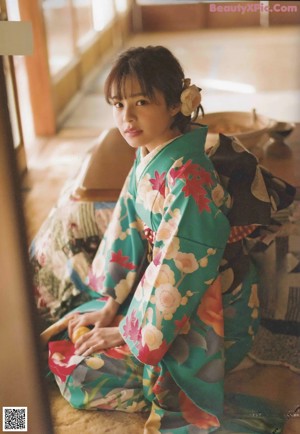 A woman in a kimono standing on a set of stairs.