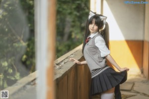 A woman in a white shirt and black skirt posing for a picture.