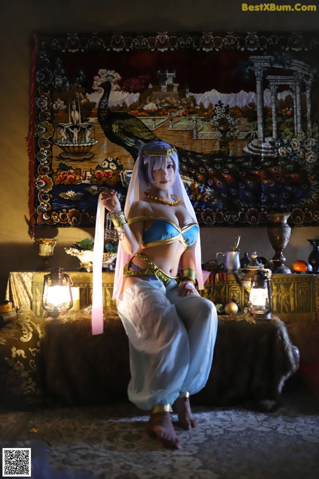 A woman in a blue and white outfit sitting on a couch.