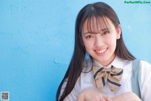 A woman in a school uniform is standing on a ledge.