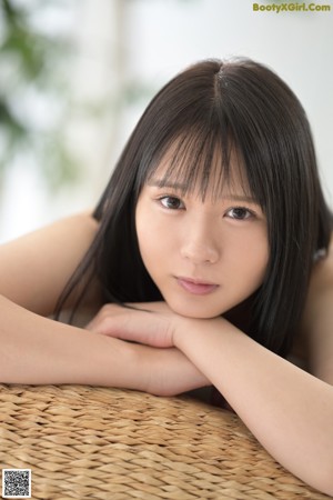 A naked asian woman in a white thong posing for the camera.