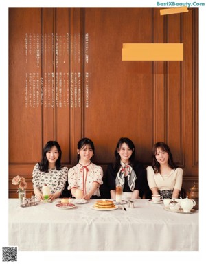 A group of young women sitting at a table eating food.