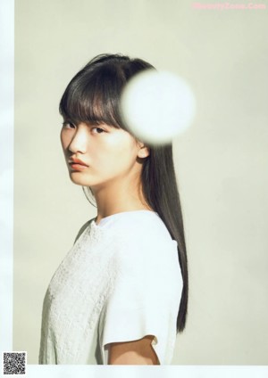 A woman with long black hair and a white shirt.