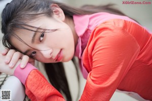 A woman in a pink shirt is bending over.