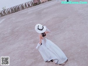 A woman in a white dress sitting on some steps.