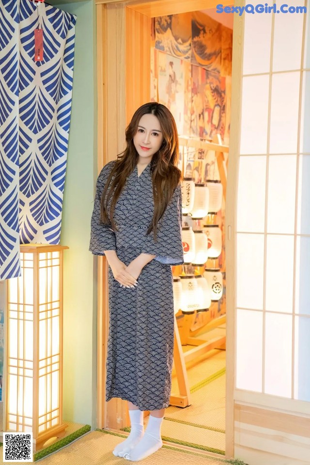 A woman standing in front of a door in a room.