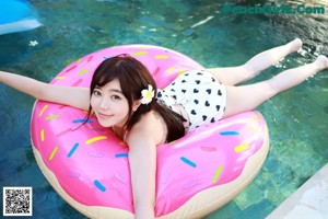 A woman in a white bikini sitting in a bathtub.