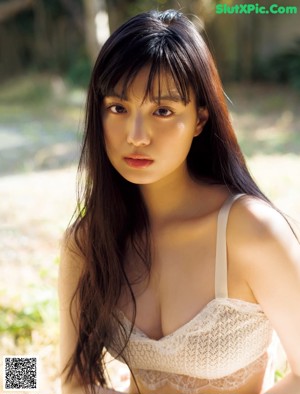 A woman in a white bra and panties posing for a magazine.