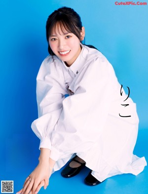 A woman in a white shirt posing for a picture.