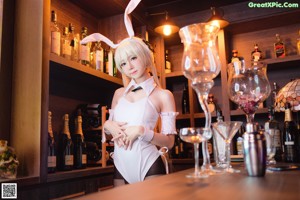 A woman in a bunny costume sitting on a bar.