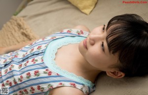 A woman laying on a bed with a teddy bear.