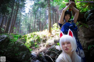 A woman laying on the ground in the woods.