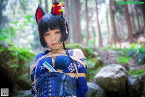 A woman in a kimono standing in the woods.