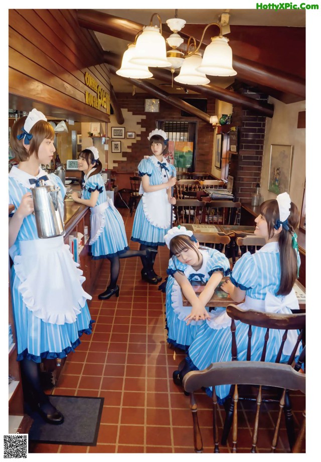 A group of young women dressed in maid outfits in a restaurant.