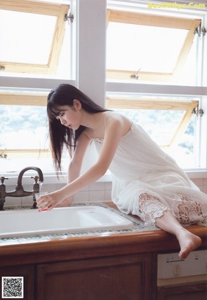 A woman sitting on top of a bed with her legs crossed.