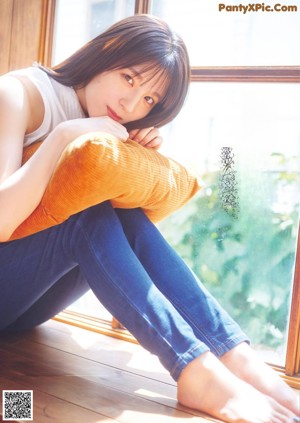 A woman in a white shirt is looking at the camera.